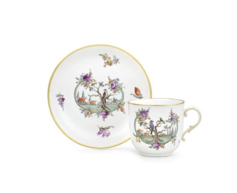 A Nymphenburg coffee cup and saucer, circa 1775Each painted with a bird perched on a tree in a landscape above a green rocail