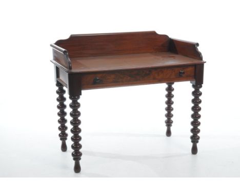 A Victorian mahogany wash stand
The rectangular top with a paper scroll gallery above a single frieze drawer with button hand