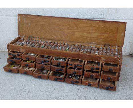 Watchmaker's twenty one drawer wooden chest with hinged top containing a quantity of parts and accessories to include staffs,