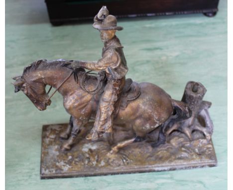 A vintage spelter table top touch lighter in the form of a cowboy on horse, 9 1/2" high
