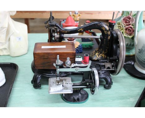 An antique Jones manual sewing machine plus a childs size Singer sewing machine