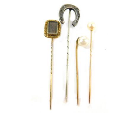 Four stick pins, comprising a silver horseshoe pin, a Victorian memorial pin, yellow metal, unmarked, and two others with cul