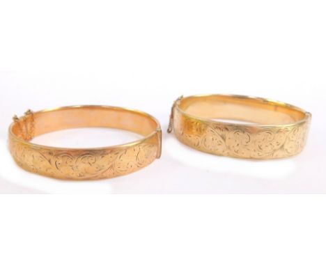 Two hinged bangles, one a partially scroll design bangle,  marked 9ct case, and another of similar design with the same marki