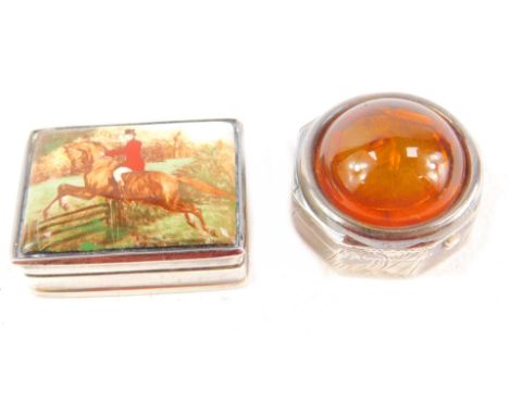 A silver and enamel pill box, decorated with a huntsman leaping a gate, 3.5cm L, and a silver and amber pill box, of octagona