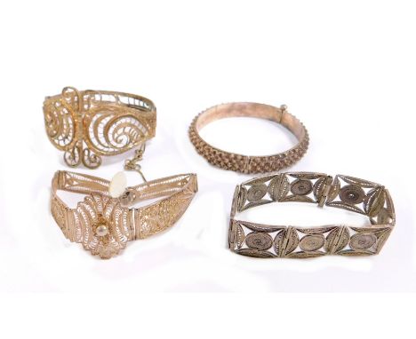 Four filigree design bracelets, comprising a silver plated filigree square design links, an elaborate silver plated scroll de