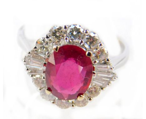 An 18ct white gold ruby and diamond ring, the oval cut ring in a surround of baguette and brilliant cut diamonds, ruby approx