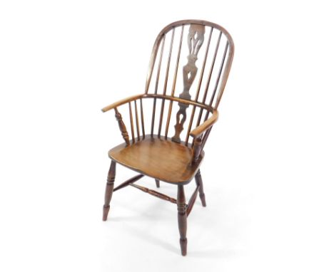 A 19thC oak and elm stick back Windsor chair, with a carved splat, solid seat, raised on turned legs.