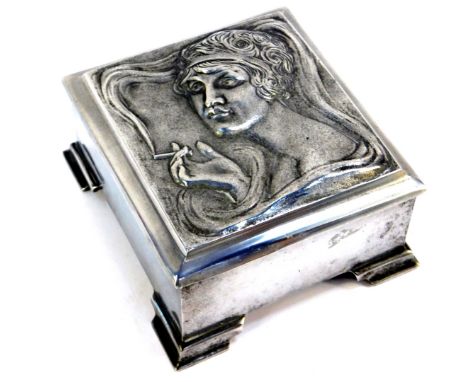 An Art Nouveau metal musical cigarette box, the hinged lid cast with a bust profile of a lady smoking a cigarette, in high an