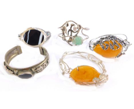 Five stone set bangles, comprising an abstract amber style set bracelet, silver plated, an abstract silver bangle set with pa