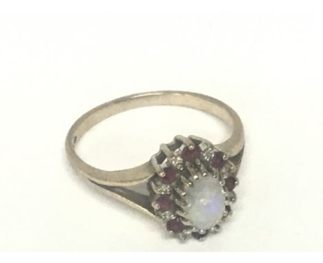 A 9carat gold ring set with an oval Opal flanked by further stones. Weight 2.4g ring size P.