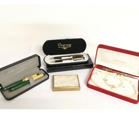 A collection of cased pens, a compact mirror and a simulated pearl necklace. Postage category C. NO RESERVE