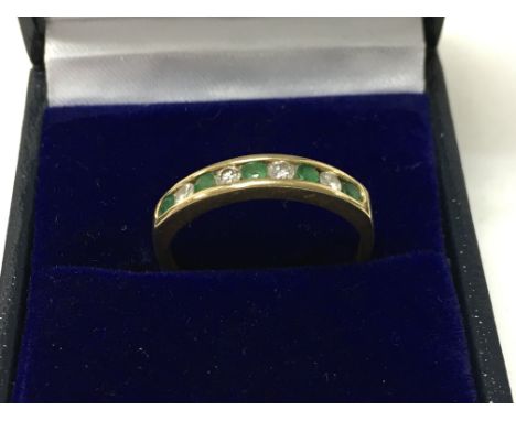 An 18ct gold emerald and diamond set half eternity ring. Size P/Q. Total weight 2.5g. Postage category a