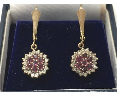 A 9ct gold pair of diamond and ruby earrings. 2.6g total weight. Postage category a