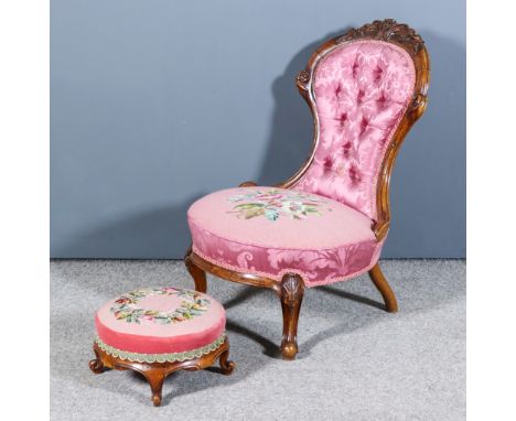 A Victorian Walnut Framed Low Spoon Back Nursing Chair, the moulded frame with leaf scroll carved cresting, upholstered in fl