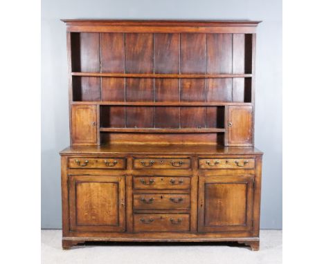 An 18th Century Panelled Oak Dresser, the upper part with moulded cornice, fitted three open shelves and two small cupboards 