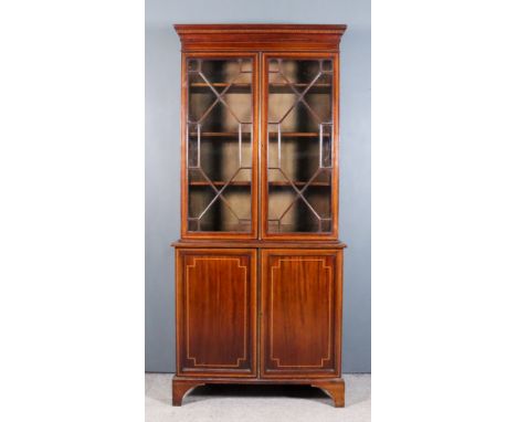 An Edwardian Mahogany Bookcase of "Georgian" Design, the whole inlaid with satinwood bandings and stringings, the upper part 