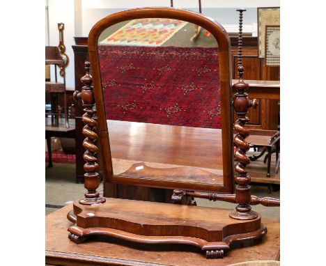 A Victorian mahogany dressing table mirror, the barley twist uprights on a serpentine platform raised on flat scroll feet, 74