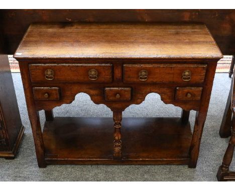 A Titchmarsh &amp; Goodwin oak dresser base of small proportions, fitted with an arrangement of drawers and with a shelf stre