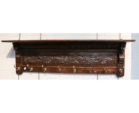 An early 20th century carved oak eight rack hall shelf, 139cm by 23cm by 41cm, together with a smaller example, 80cm by 29cm 