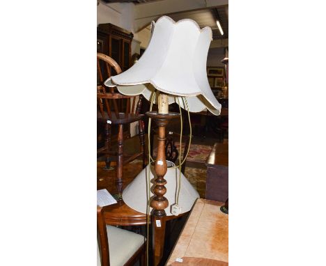 An early 20th century walnut standard lamp raised on a tapering hexagonal pedestal over an octagonal plinth