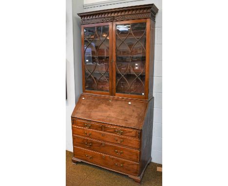 A George III mahogany bureau bookcase with a blind fret carved frieze and astragal glazed doors, with fitted interior and rai
