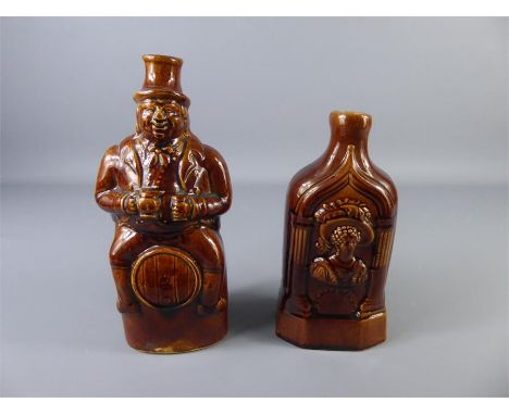 Circa Early 19th Century Brown Glazed Spirit Flasks, including a figural character seated on a barrel and the other moulded i