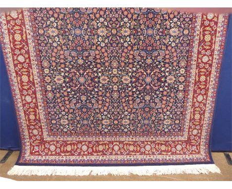 A Signed Woollen Hereke Carpet, with a cobalt blue ground with burgundy and cream foliate and geometric design, approx 200 x 