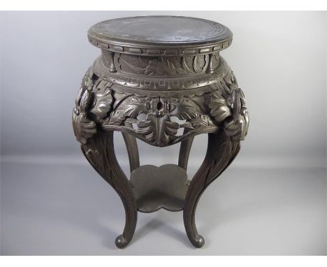 A Chinese Plant Stand, the surface having a Greek key design, ornate carved skirt supported on cabriole legs, shelf beneath, 