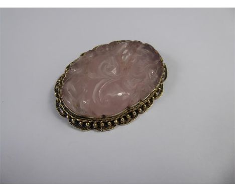 A Chinese Hand Carved Silver Gilt and Rose Quartz Brooch, carved with peony in silver beaded mount, approx 55 x 40 mm.