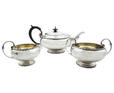 Early 20th century three piece silver tea service, comprising teapot with ebonised handle and finial, twin handled sucrier, a