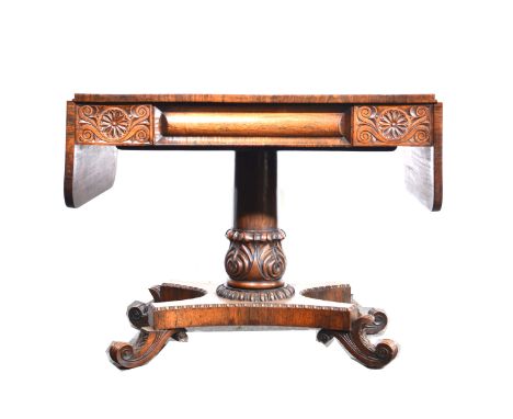 Regency rosewood sofa table, rectangular top with two rounded drop leaves, frieze drawer, turned and carved column curned pla