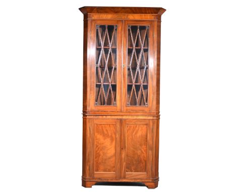 Victorian mahogany freestanding corner cabinet, the upper section with glazed doors enclosing shelves, the base with two pane