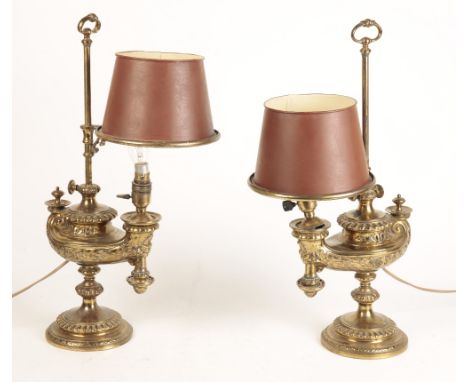 PAIR BRASS TABLE LAMPS, late 19th century, the "Aladdin"-style oil lamps with lamp shades, on circular bases, 55cm high (2)