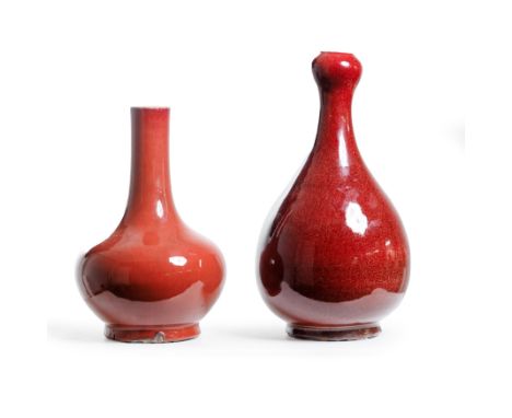 Two Chinese monochrome red-glazed vasesMid Qing dynastyThe first, thickly potted in a pear-shaped form terminating in a garli