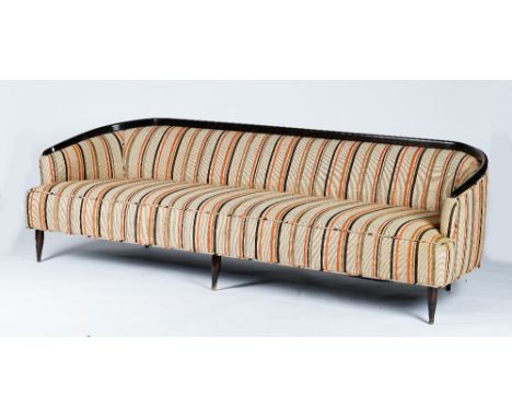 A sleek sofa, circa 1950, with curved dark stained frame, upholstered in orange and brown stripe fabric, 230cm wide 73cm high