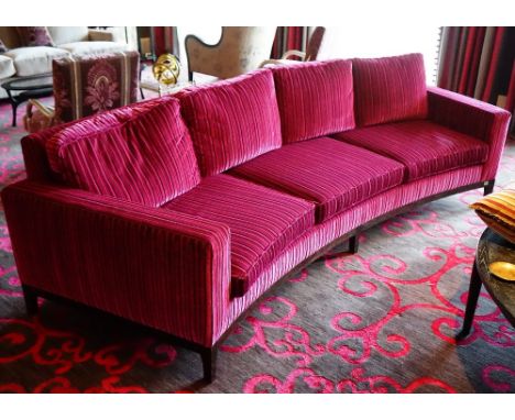 A contemporary curved three seat sofa, upholstered in striped black and magenta with loose back and seat cushions, with faux 