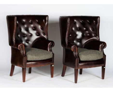 A pair of reproduction George III style armchairs with curved button-down upholstered leather backs and sides, and loose seat