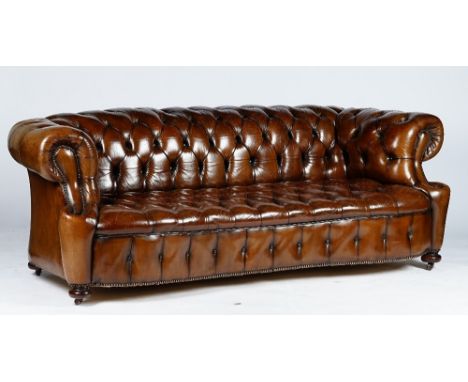 A Victorian style Chesterfield settee, button upholstered in brown leather with close nailed arms, on bun feet and castors, 2