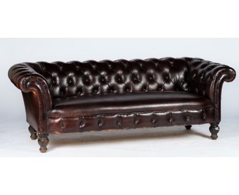 A Victorian style Chesterfield settee, button upholstered in brown leather with close nailed arms, on bun feet and castors, 2