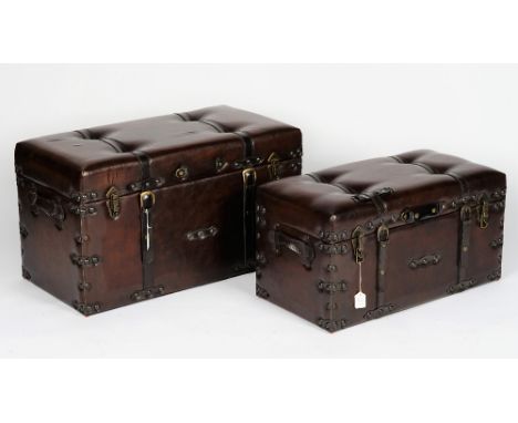 A graduated pair of chocolate brown leather trunks with button-down tops, the largest 83cm wide x 45cm high, the smallest 73c
