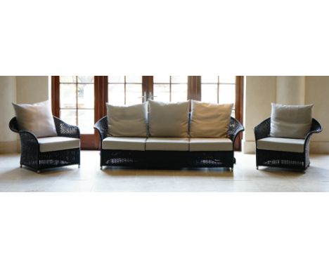 A three piece grey wicker loggia suite, with pale grey leather cushions, the chairs 94cm wide x 75cm high, the sofa 119cm wid