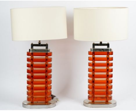 A pair of amber perspex and nickel plated table lamps, circa 1960, of oval form, in Art Deco style.*** Originally in a hotel 