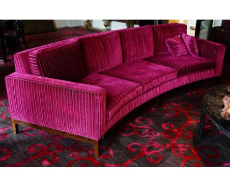 A contemporary curved three seat sofa, upholstered in striped black and magenta with loose back and seat cushions, with faux 