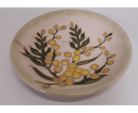 A small round Moorcroft pin dish, tubelined and decorated with round yellow berries and greenery on a cream and light green g