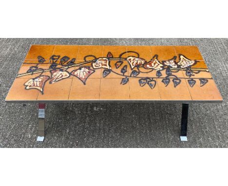 A mid-20th century tile top coffee table, the tiles with an ochre ground and variously decorated with stylised flowers, on ch