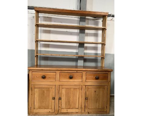 A 20th century pine dresser, the top of open shelf design, the base with three short drawers above three cupboard doors, 222c
