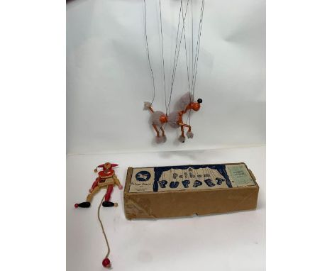 A Pelham puppet of a poodle, with painted pinky orange body and lilac fur, together with  wooden jester toy; both contained i