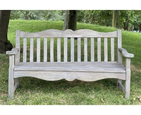 GARDEN BENCH BY BRIDGMAN &amp; CO, well weathered teak with shaped, incised top rail, slatted seat and scroll flat top arms, 