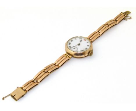 An early 20th Century 9ct gold cased wristwatch, the circular white enamel dial with Arabic hour markers, outer minutes track