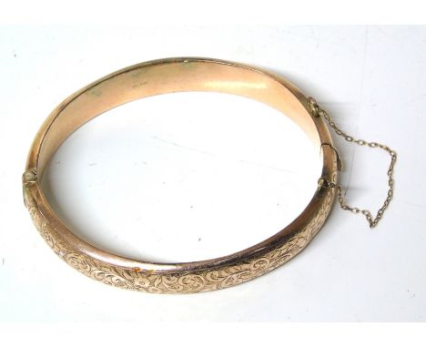 A 9ct gold hinged bangle, the foliate front with plain reverse, hallmarks for Chester, 1918, gross weight 11.5g. We do not su